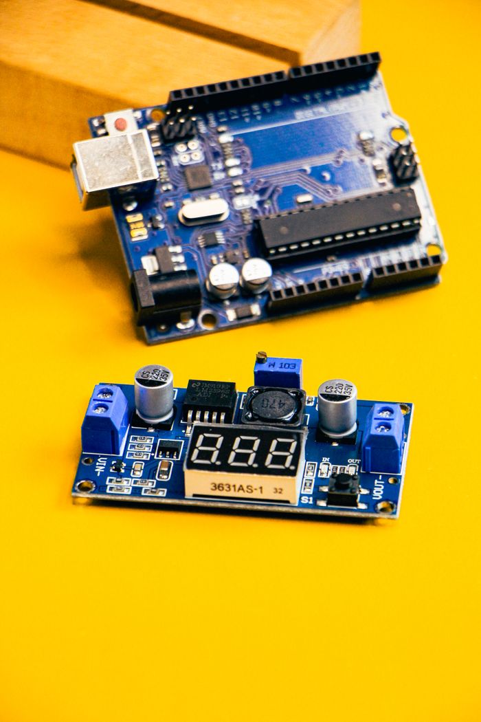 gallery-6 Close-up of an Arduino circuit board and sensor module on a bright yellow background.
